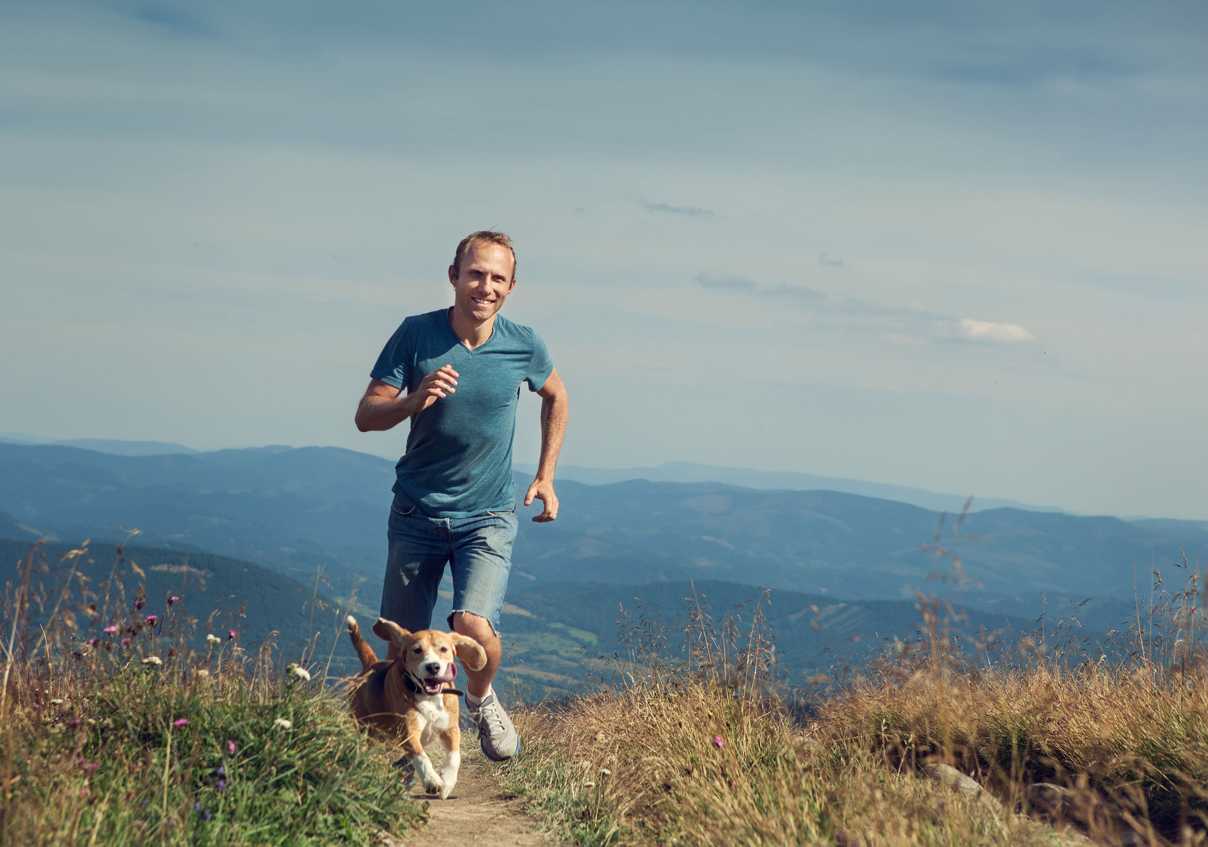 44503426 – man running with his dog on the mountain tableland